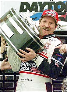 Picture of Dale celbrating and holding up a winning trophy.