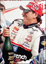 Picture of Dale celebrating with a large bottle of champagne.
