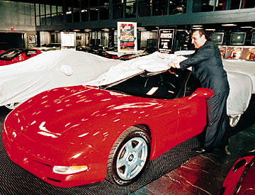 It's been a long time coming, but today Chevrolet has a
completely redesigned Corvette in showrooms - a select few
showrooms, anyway. Above, George Kerbeck gives a peek at
one of the new 1997 models at his dealership in Atlantic City,
N.J. But Hawaii Corvette fans must wait a little longer.