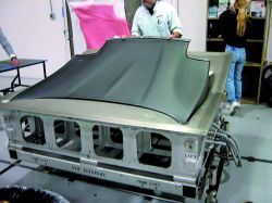 Following cure, the carbon fiber hood outer panels are demolded and the edges trimmed on a 5-axis CNC router. Source: MacLean Quality Composites
