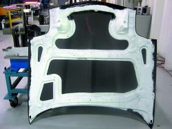 The bonded hood assembly shows the compression molded inner panel, supplied by Meridian Automotive Systems. Low-density SMC (light gray) is co-molded with carbon fiber SMC (perimeter of inner panel). Source: MacLean Quality Composites