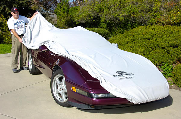 Hib Halverson applies car cover to his Corvette
