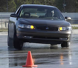 The author, caught by photographer, Aaron Vandersommers, at a tire test in Florida in early February of 2004. Looking at the car's lack of roll stiffness, clearly, Buicks are not great slalom cars but they are very typical of daily driver sedans.